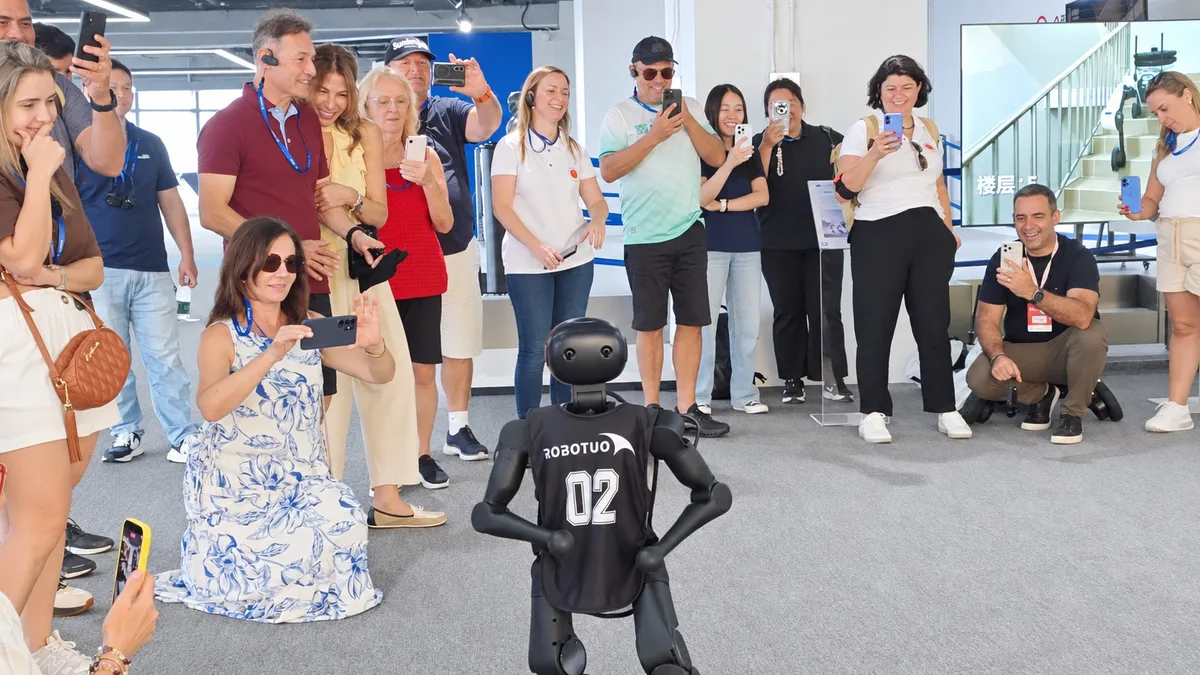 International visitors exchanging ideas around a Robotuo robot demonstration