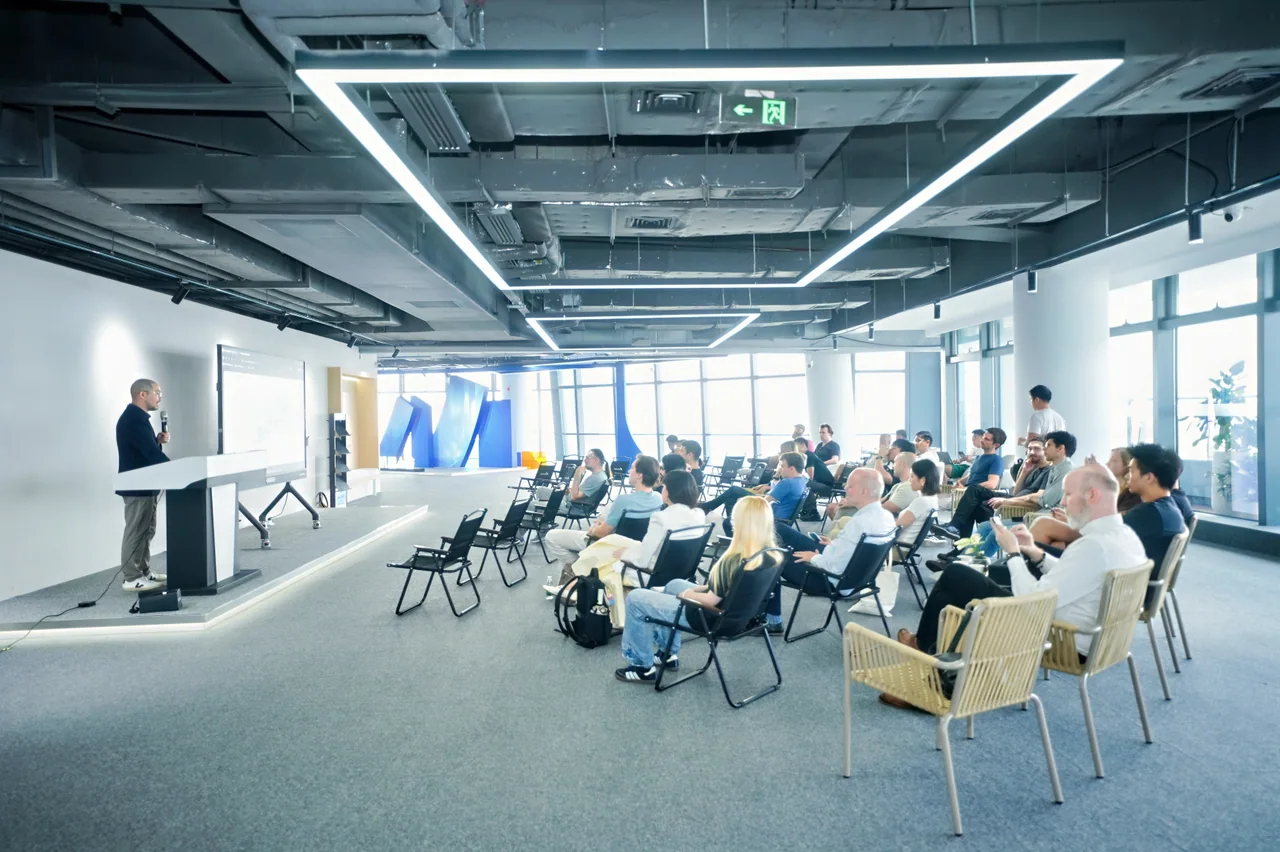 An audience of international visitors listens to a presentation inside Robot Valley.