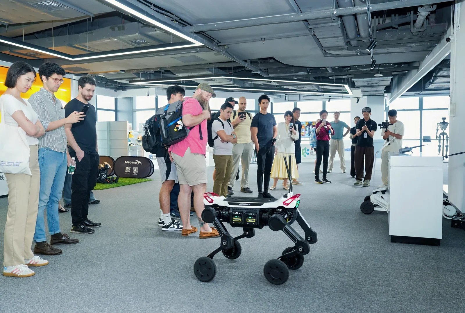 Visitors gather around a wheeled quadruped robot during a live demonstration at Robot Valley.