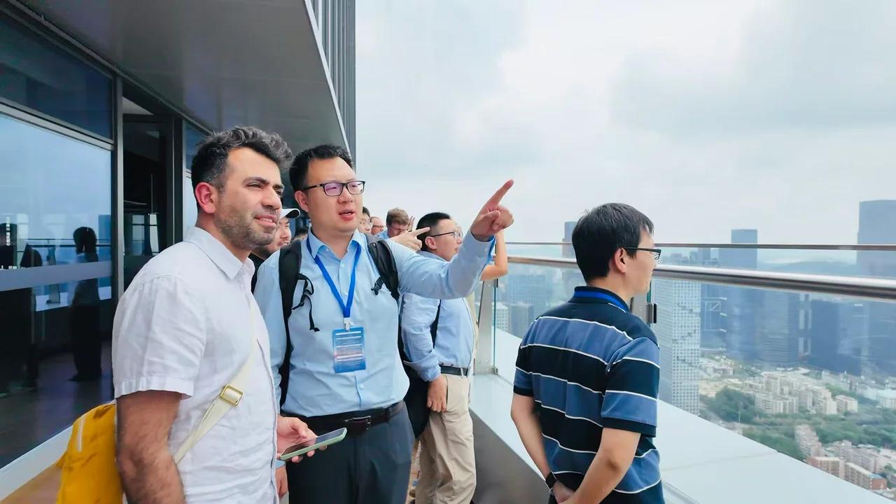 A guide points out the city to visitors on the glass-railed Robot Valley sky deck.